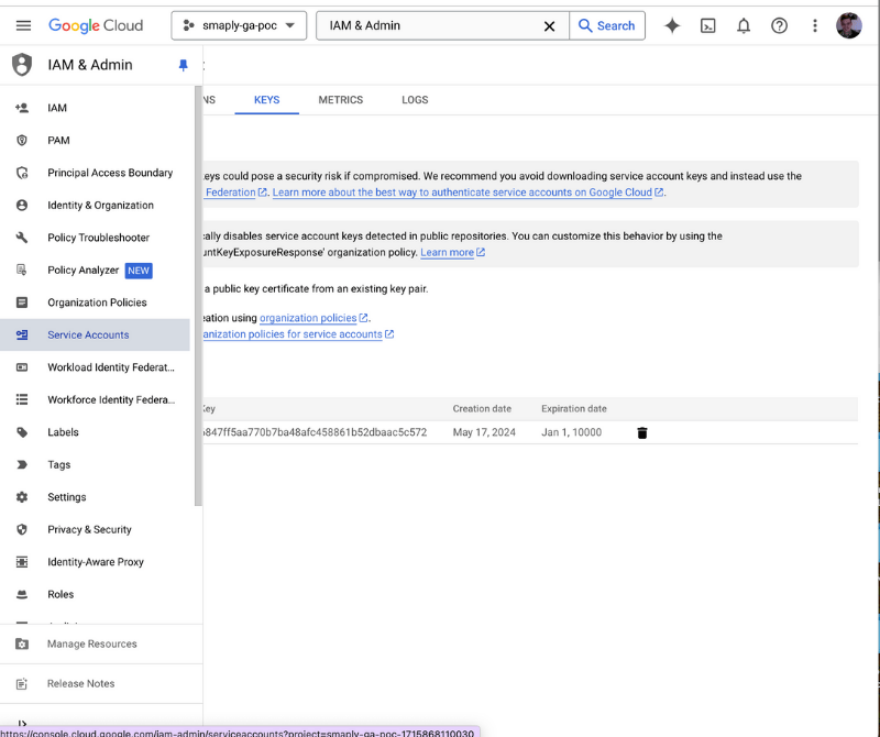 Google Cloud Console Service Accounts page with the Keys tab selected, where you create a new JSON key. The page shows an existing key row with creation and expiration dates, alongside Google's security-warning banners about downloading service account keys.
